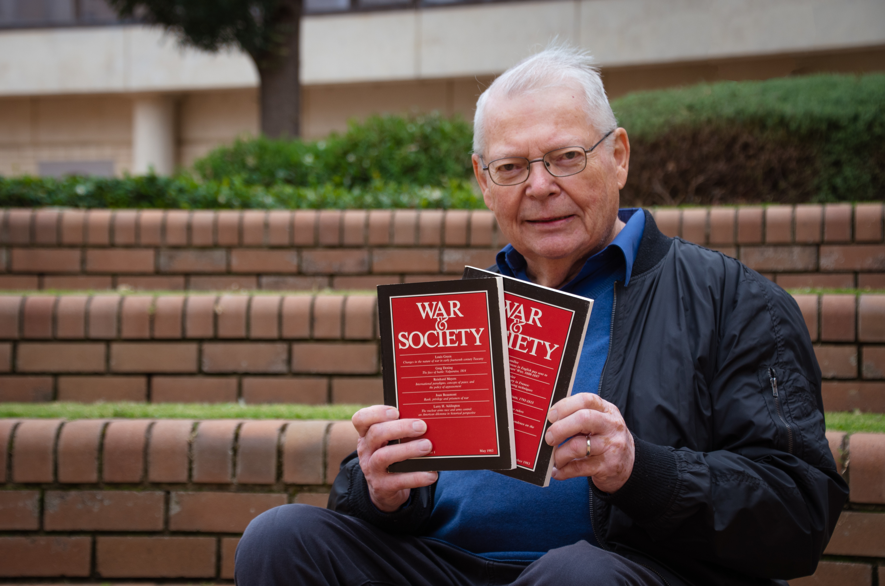 Professor Peter Dennis holds two books titled &#039;War &amp; Society&#039;