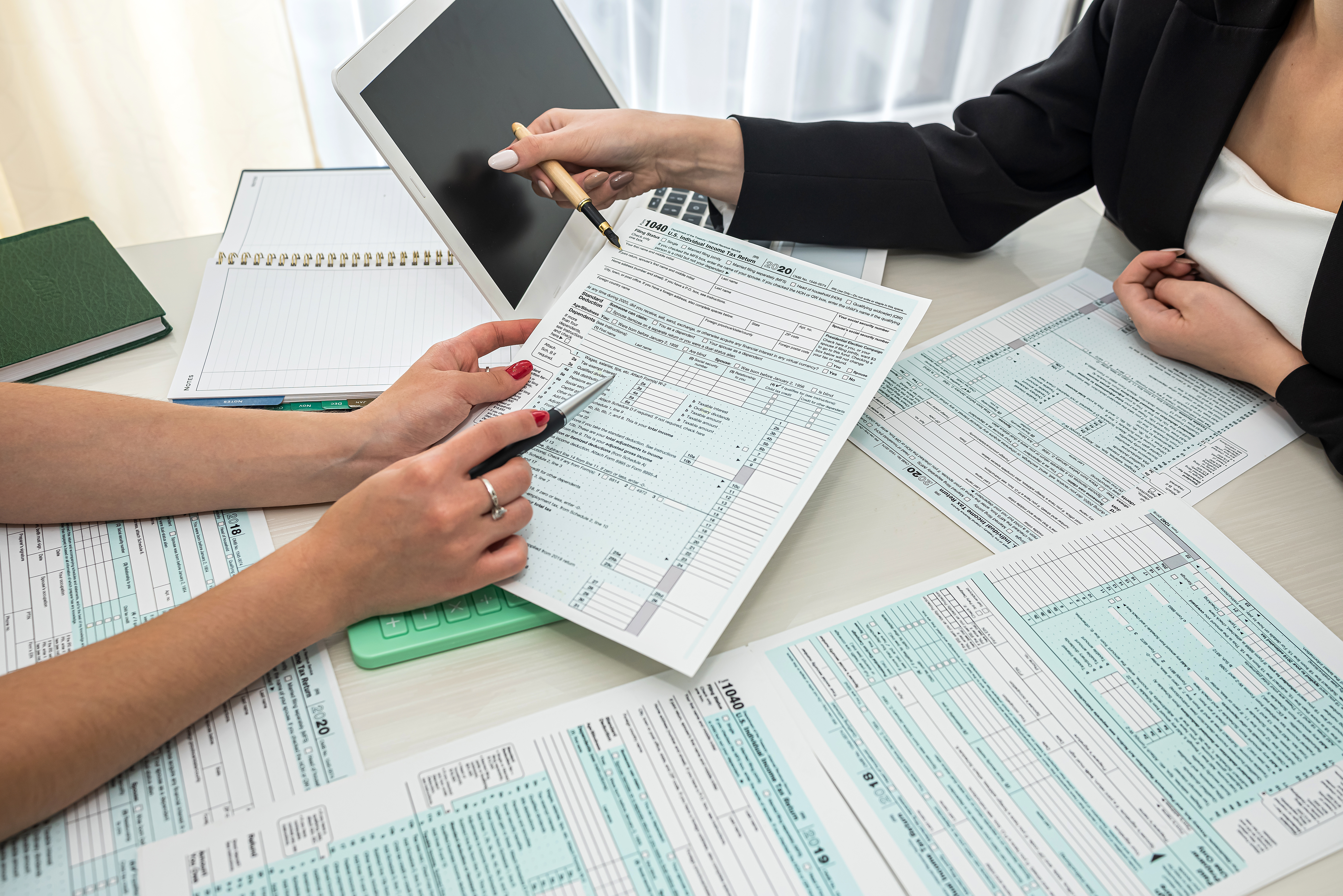 Two people point at tax forms
