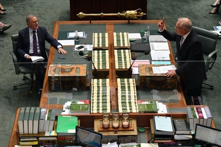 picture of two men at a desk in parliament house 