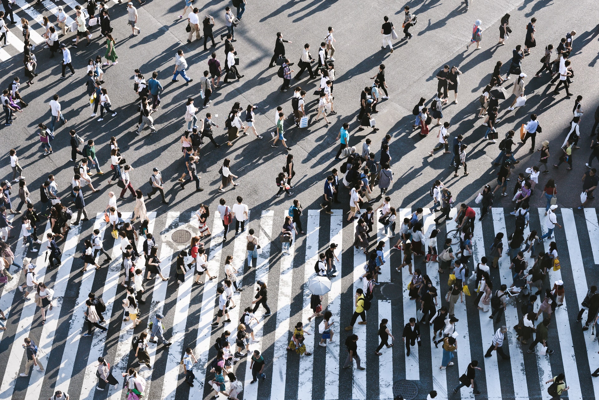 Aerial view of a crowd of people crossing a large crosswalk 