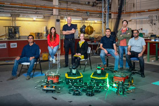 Professor Matt Garratt and Professor Kathryn Kasmarik's robotics team pictured with robots. 
