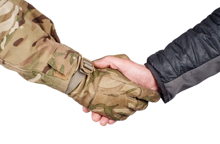Army uniformed arm shaking hands with civilian uniformed arm