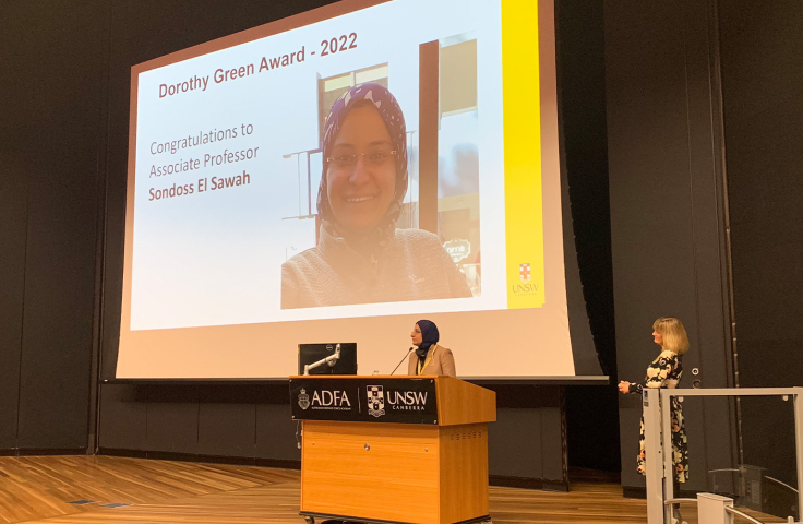 A/Prof. Sondoss Elsawah delivers a speech while receiving the Dorothy Green Award. Rector Professor Emma Sparks watches from the side of the stage. 