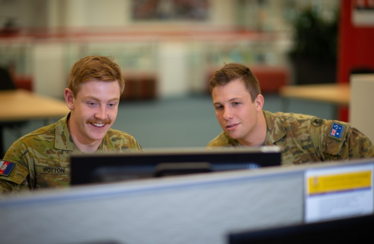 Two cadets sitting at a computer