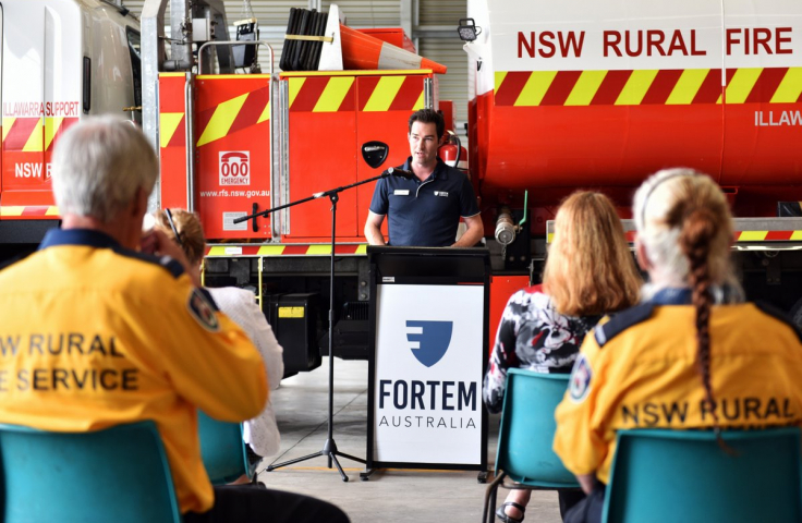 John Bale addresses Rural Fire Service with fire truck in background. 