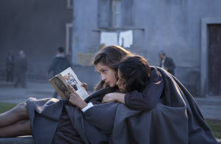 Woman hugging another woman reading a book 