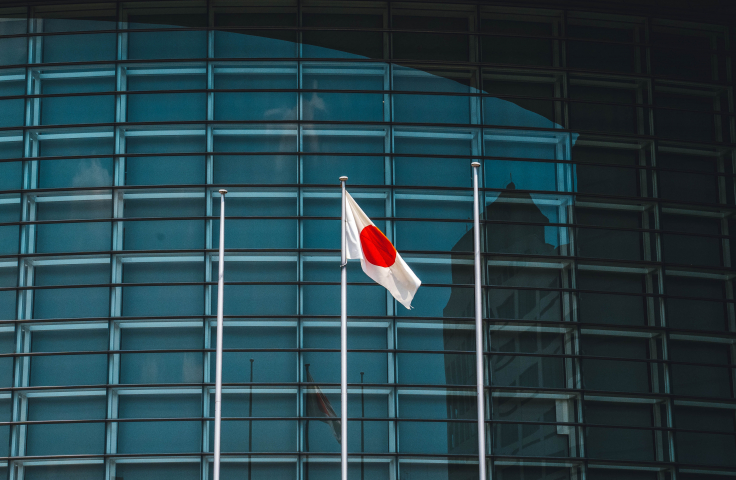 A Japanese flag in front of tower building